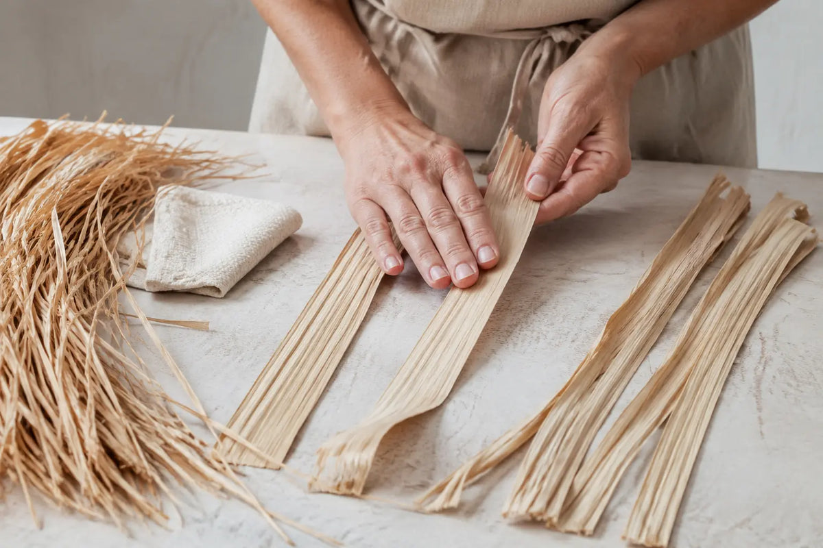 Préparation manuelle de bandes de raphia avant le travail au crochet