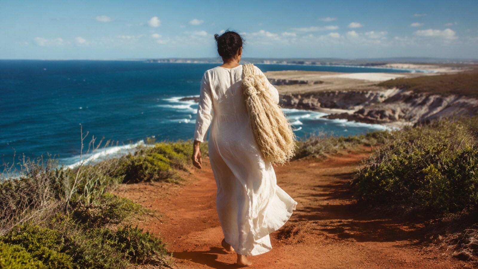Femme marchant sur un sentier côtier de Madagascar