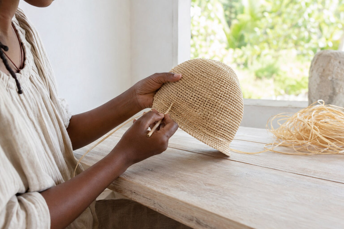 Artisane ajustant la tension d’un chapeau en raphia au crochet