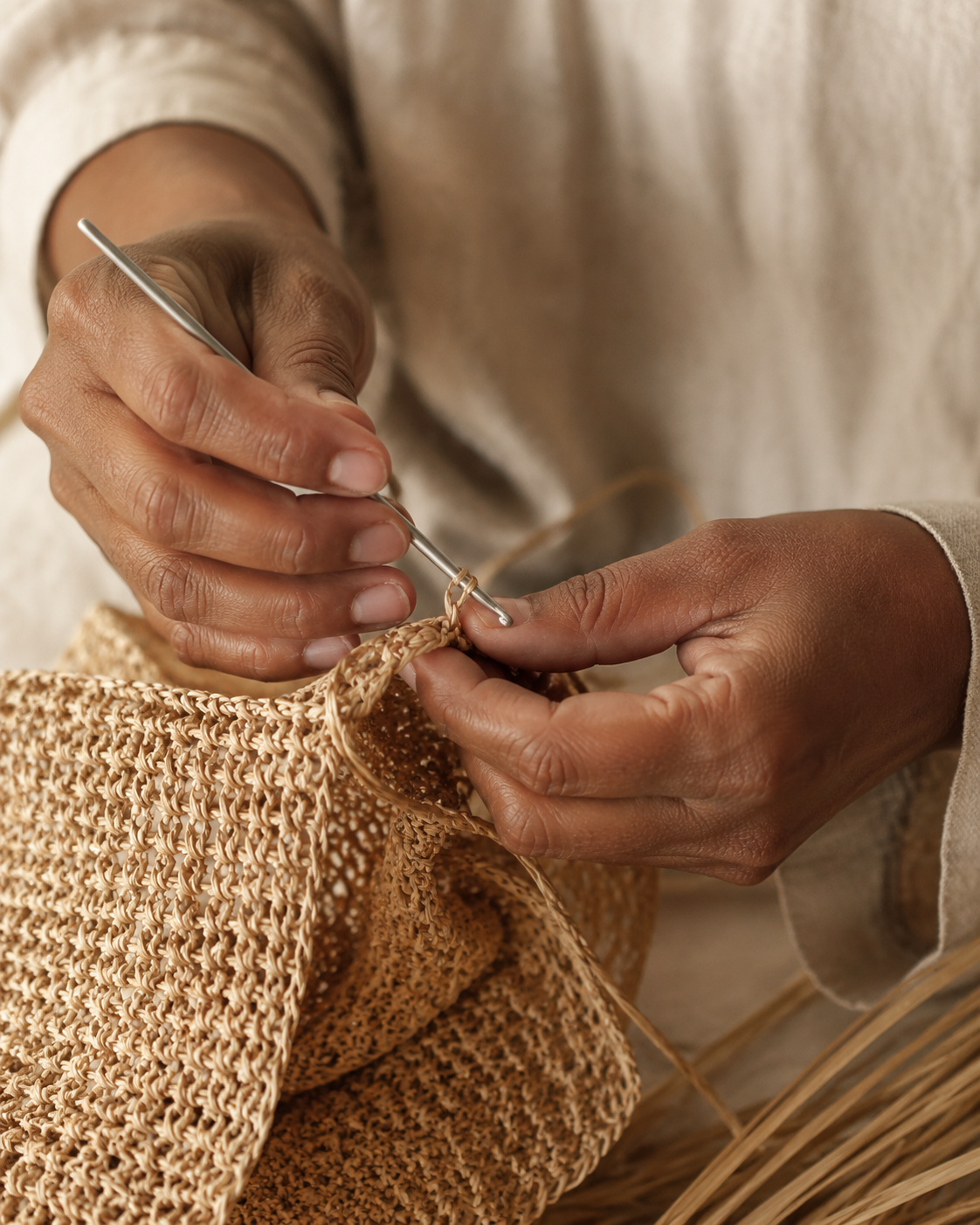 Mains d’artisane façonnant le raphia au crochet